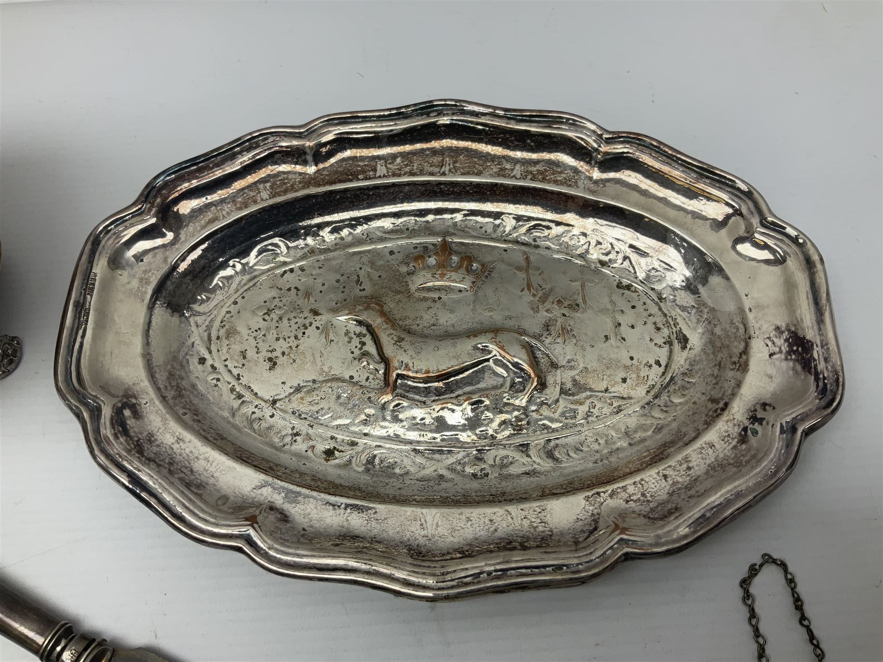 Silver plated tray, with shaped rim and embossed with a dog and crown to centre, stamped Valenti, together with three silver plated decanter labels, two port and one Bucellas, a plated cream jug with embossed floral decoration and a pair of plated fish knives engraved with double headed eagle to handle, tray W25.5