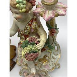 A group of assorted figures, to include a 19th century pottery figural group modelled as a flower seller with child upon her back stood before bocage, H18.5cm, a 19th century porcelain cherub candlestick modelled as Autumn, a Derby style figure modelled as a classical female, a French model of a Dove with spurious marks beneath, and two further figures modelled as Zeus and Poseidon, each with spurious anchor mark, etc.   