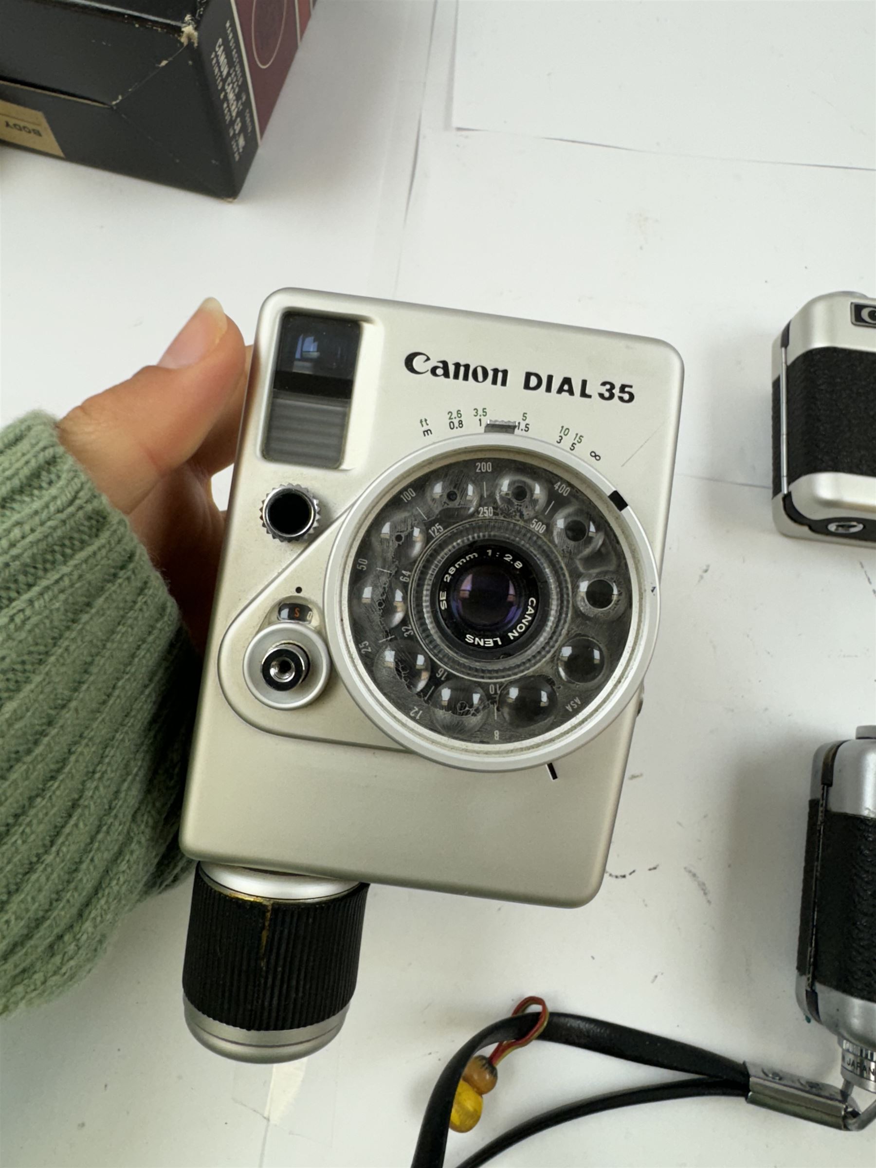 Three Canon half frame cameras, comprising two Canon Demi examples, serial nos. 243090 & 704714, one example boxed, and a Canon Dial35 serial no. 341572