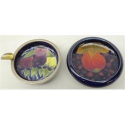  Moorcroft dish decorated in the pomegranate pattern on blue ground, D11cm, and Moorcroft dish decorated with plums on blue ground with a metal mount converted to an ashtray, D10cm  