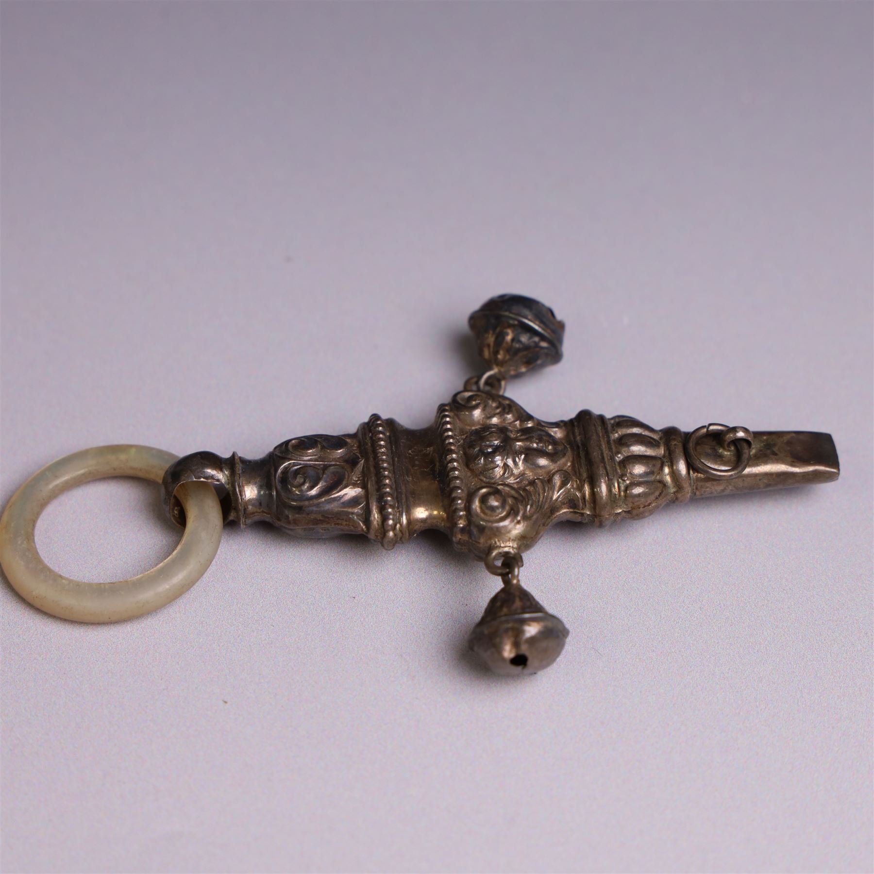 Edwardian silver rattle, embossed with putti and scrolling decoration, with whistle, bells and mother of pearl teething ring, hallmarked Crisford & Norris Ltd, Birmingham 1906, L10cm