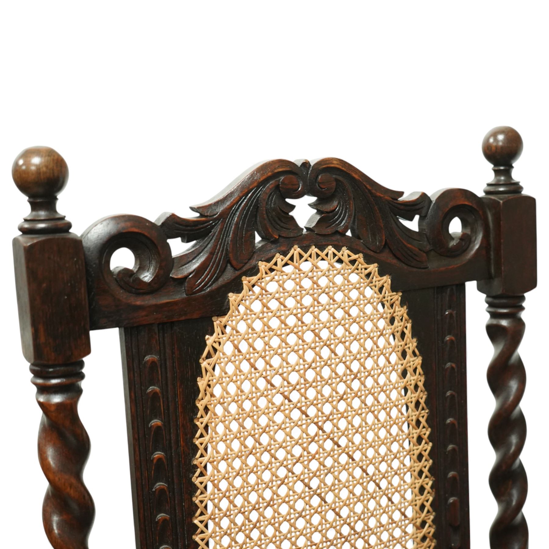 Victorian Jacobean revival oak carver chair, carved scroll cresting rail over an oval back panel later caned, open arms on barley-twist supports, padded seat, raised on spiral turned legs united by a shaped front stretcher
