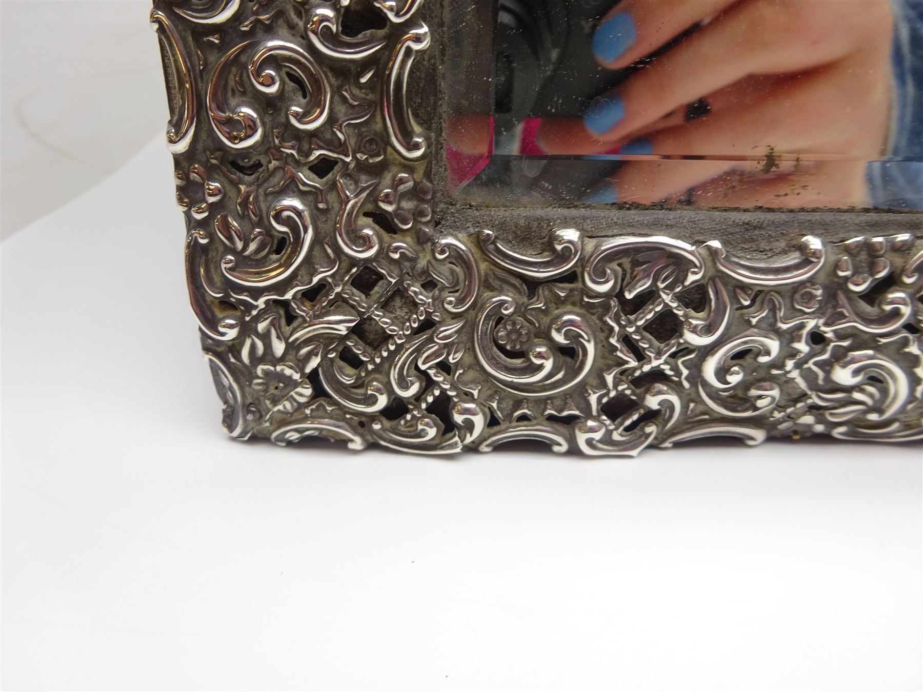 Early 20th century continental silver mounted dressing table top mirror, of rectangular form, the frame embossed with vacant reserve, lattice work, flower heads and C scrolls, with easel style support verso, unmarked but tests as silver, overall H49.5cm W31.5cm