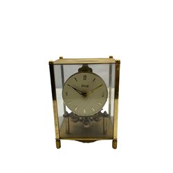 A 20th century English Torsion clock marketed by Bentime Ltd, London, with a four-ball rotary pendulum, white dial with gilt Arabic numerals and pierced gilt hands, under a glass dome, base with adjustable feet. No key.
Bentime Ltd did not make clocks but marketed clocks made by other companies such as J D Francis and Perivale.
H17
With a German Kundo torsion clock in a glazed rectangular case with four glass sides, four-ball rotary pendulum, white painted dial with gilt three-hour Arabic numerals and batons, with pierced brass hands. No key.
H15 W11 D9
