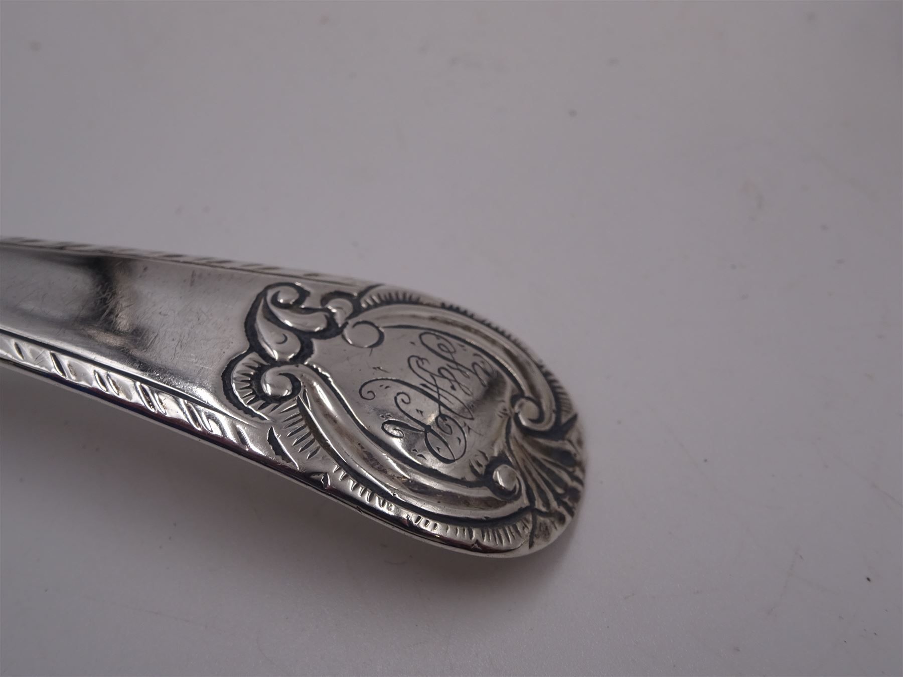 Set of three George III silver Old English pattern table spoons, each engraved with monogram to terminal and with dart border to handle, hallmarked London circa 1770, maker's mark GS, hallmarks worn and partially indisitinct