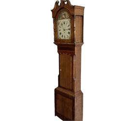 A mid-19th century 30 hour longcase clock in an oak and mahogany case with  an inset maple panel and satinwood inlay, swans necked pediment with lions head paterae, break arch hood door flanked by ring turned columns, trunk with a wavy topped door and canted corners, on a broad plinth with a raised panel, painted dial with floral scenes to the spandrels and a depiction of a country girl to the arch, with roman numerals and minute track, matching stamped brass “Crown” hands and counter clockwise date recorder, dial inscribed “ Thornton, Bradford”, chain driven movement striking the hours on a bell. With pendulum and one weight.
G.H. Thornton is recorded as working Garnett Street Bradford, 1866


