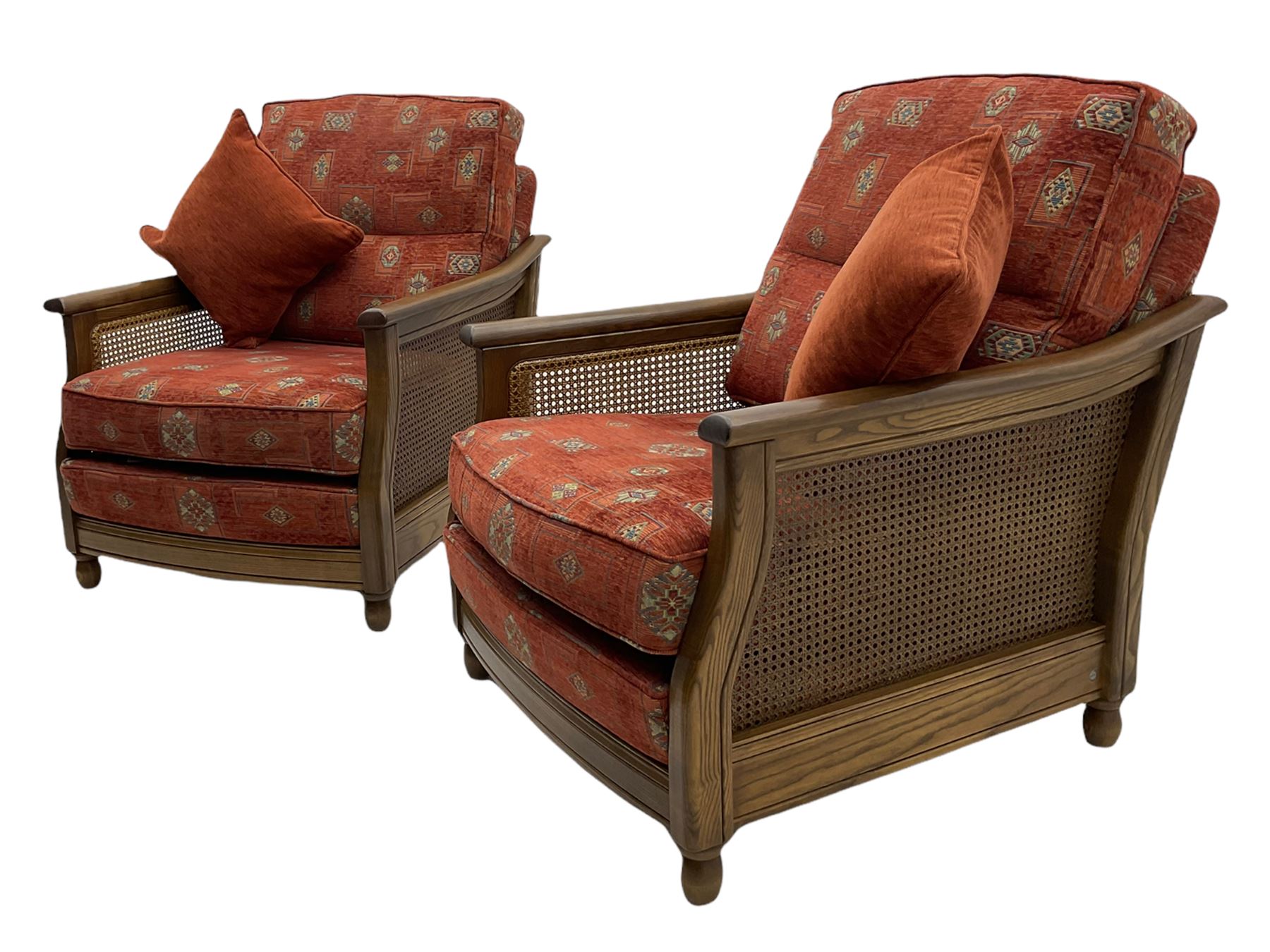 Ercol medium elm framed three seat bergere sofa, and pair of matching armchairs upholstered in red fabric