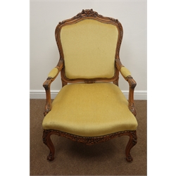  French style walnut framed elbow chair, shaped floral carved cresting rail, upholstered back, seat and arms, acanthus cabriole supports, W70cm  