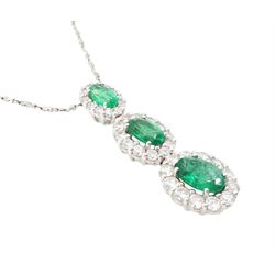 18ct white gold emerald and diamond cluster pendant, three graduating oval cut emeralds, each surrounded by round brilliant cut diamonds, Birmingham 2010, on a fine silver chain, total emerald weight approx 1.05 carat, total diamond weight approx 0.55 carat