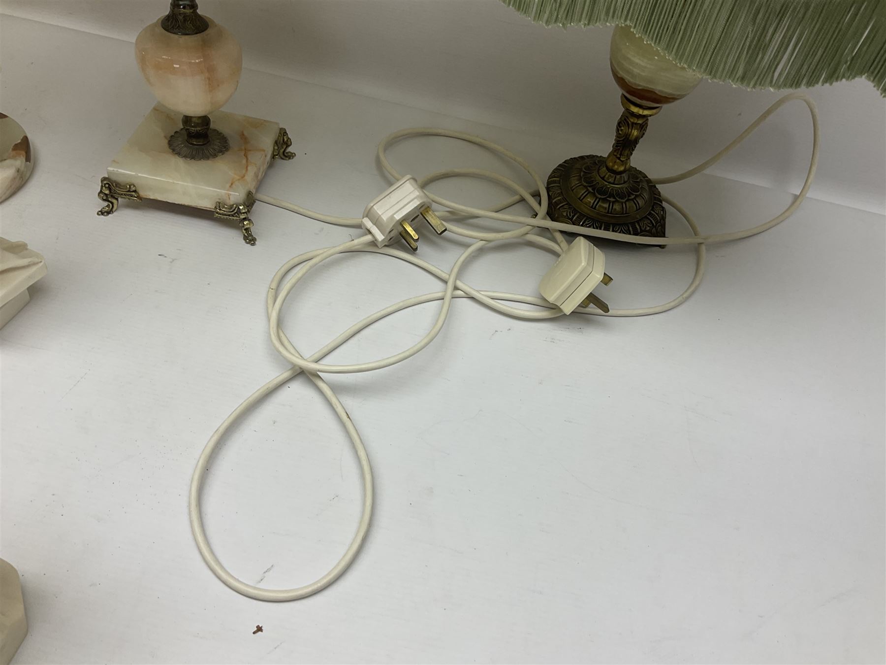 Onyx table lamp, with knopped stem and cream and green tassel shade, together with three smaller similar onyx lamps, classical style alabaster figures and a covered onyx jar