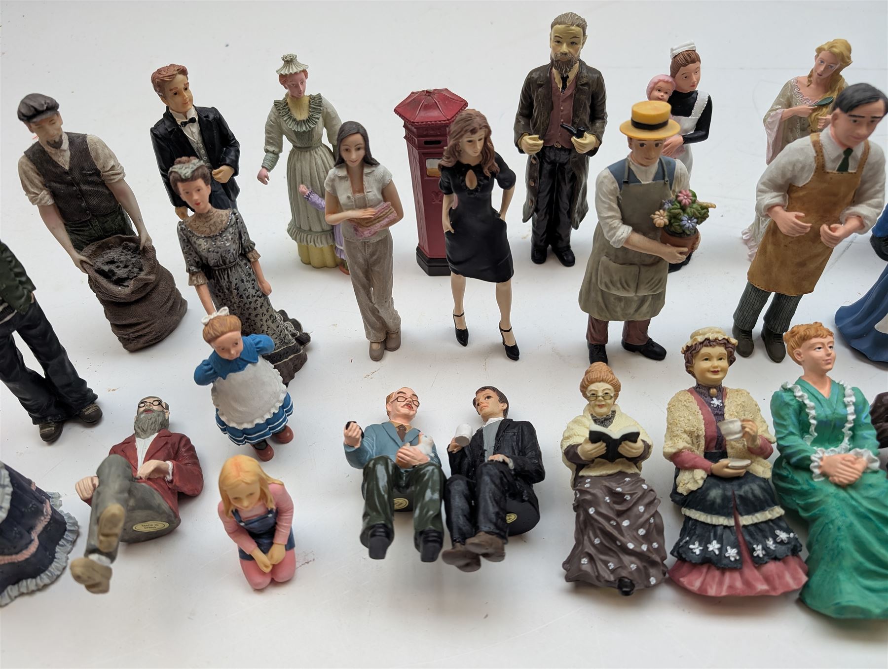 1:12 scale dolls house composite figures, including policeman, postman, maid, sitting and standing people in various styles of dress, etc