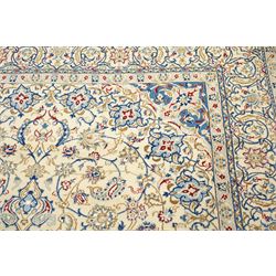 Central Persian Nain hand-knotted carpet, ivory field with central finely drawn cusped medallion of radiating palmette and arabesque form with scrolling vine work, flowering tendrils and stylized foliate motifs in a palette of pale blue, indigo, crimson and sage accents, spandrels of conforming design enclosing intricate floral sprays and arabesques within  multiple borders and narrow guard stripes, with cotton fringe ends 