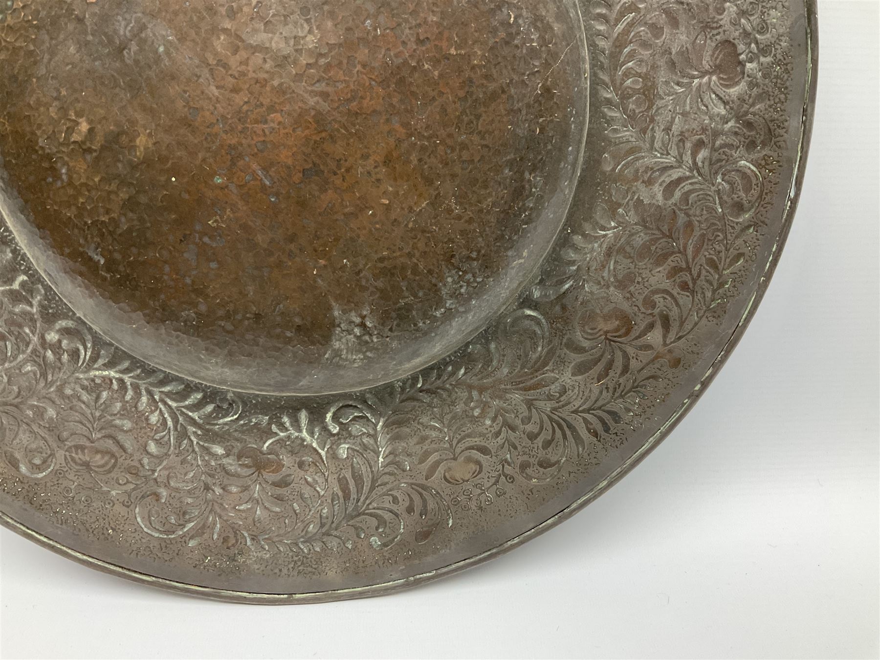 Arts and Crafts Keswick School of Industrial Arts copper charger, decorated with planished centre and repousse scrolling foliate tendrils to rim, D44cm