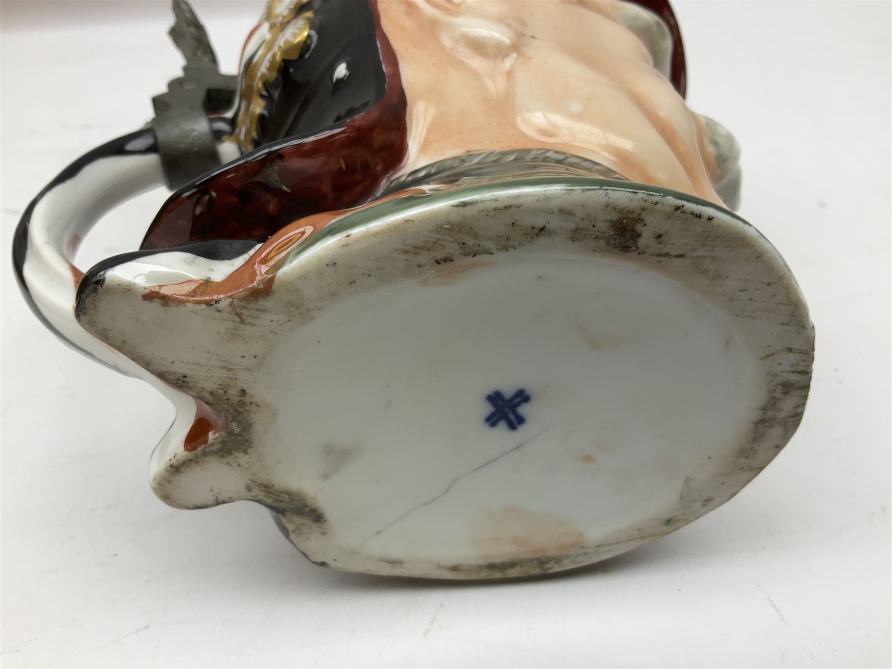 Otto Von Bismarck figural 0.5l stein, his black pickelhaube helmet with chrome spike serving as the lid, in green uniform and gilt detail throughout, pewter thumb hinge, with blue hash Musterschutz type mark, H18cm