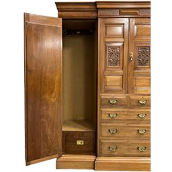 Edwardian walnut combination breakfront triple wardrobe, projecting cornice over cushioned and fluted frieze, central fielded panelled cupboard carved with foliate decoration above two short and three long drawers, flanked by two bevelled mirror doors enclosing hanging hooks with single drawers to base, retailed by J Tonks & Sons, Scarborough