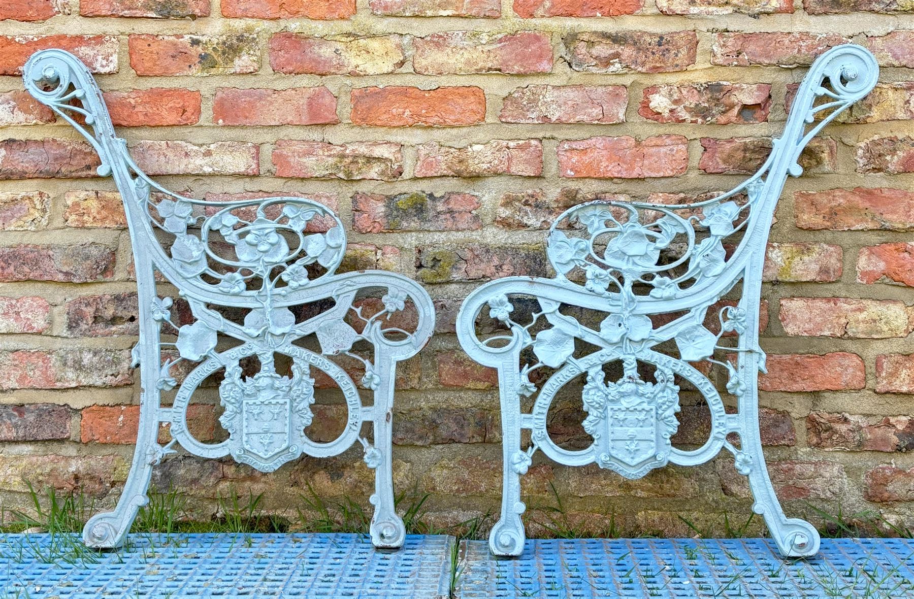 Pair of Nistercian pattern cast iron bench ends, each with cartouche inscribed 