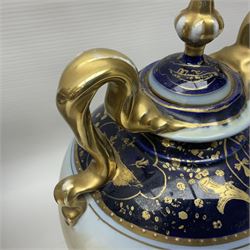 19th century Vienna style porcelain 'Musik' garniture, the central vase of baluster form with domed cover flanked by two smaller vases with twin curved gilt handles to short neck, each decorated with classical figural vignettes between blue borders heightened with gilt, H33.5cm