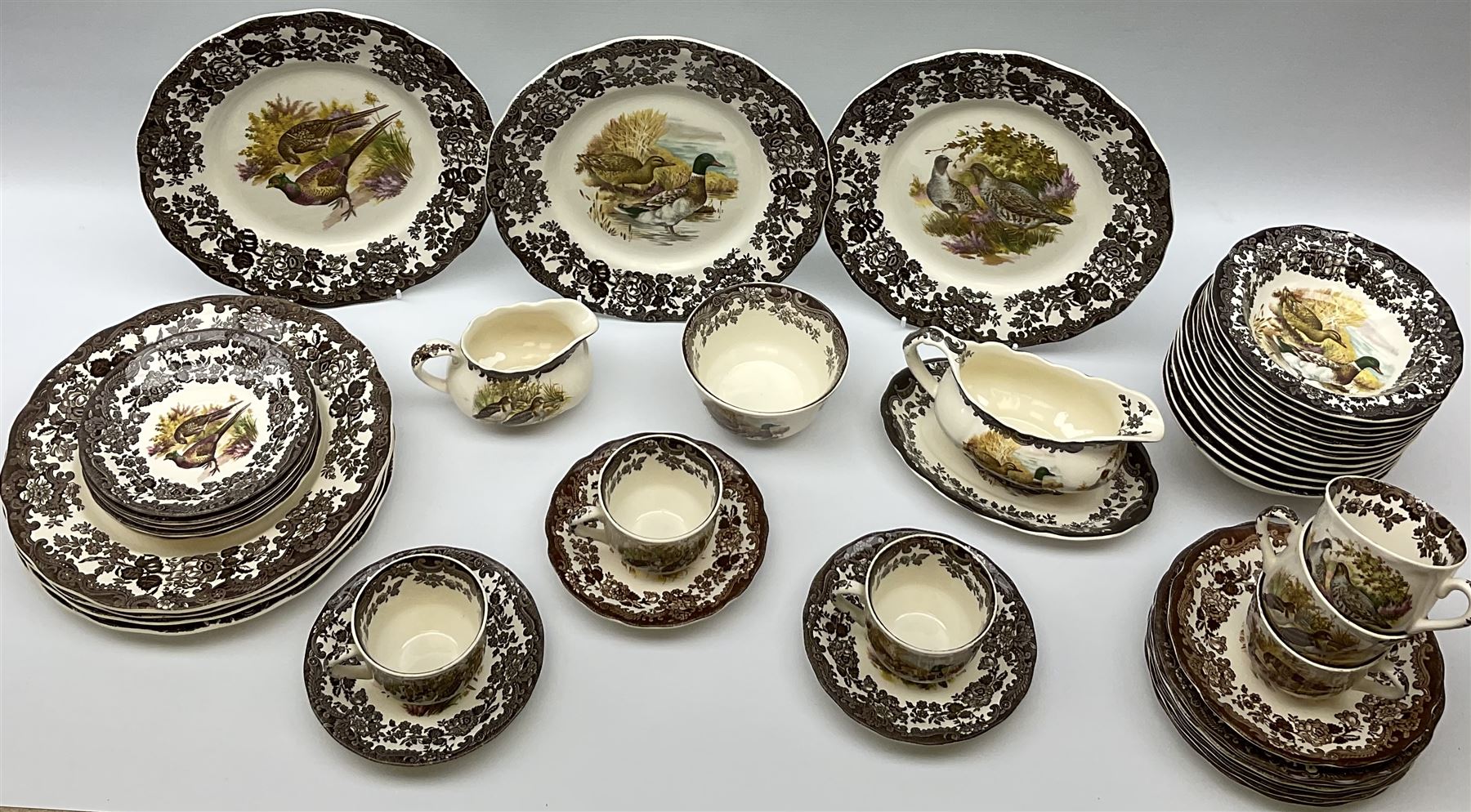Royal Worcester Palissy Game Series pattern dinner wares, comprising seven dinner plates, six side plates, twelve bowls, sauce boat and stand, six tea cups, eight saucers, further larger saucer, milk jug, and open sucrier. 