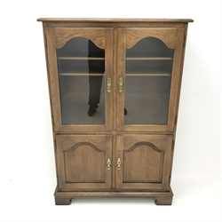 Jaycee - medium oak display cabinet, two glazed doors enclosing two shelves above two panelled cupboards, shaped bracket supports, W94cm, H140cm, D33cm
