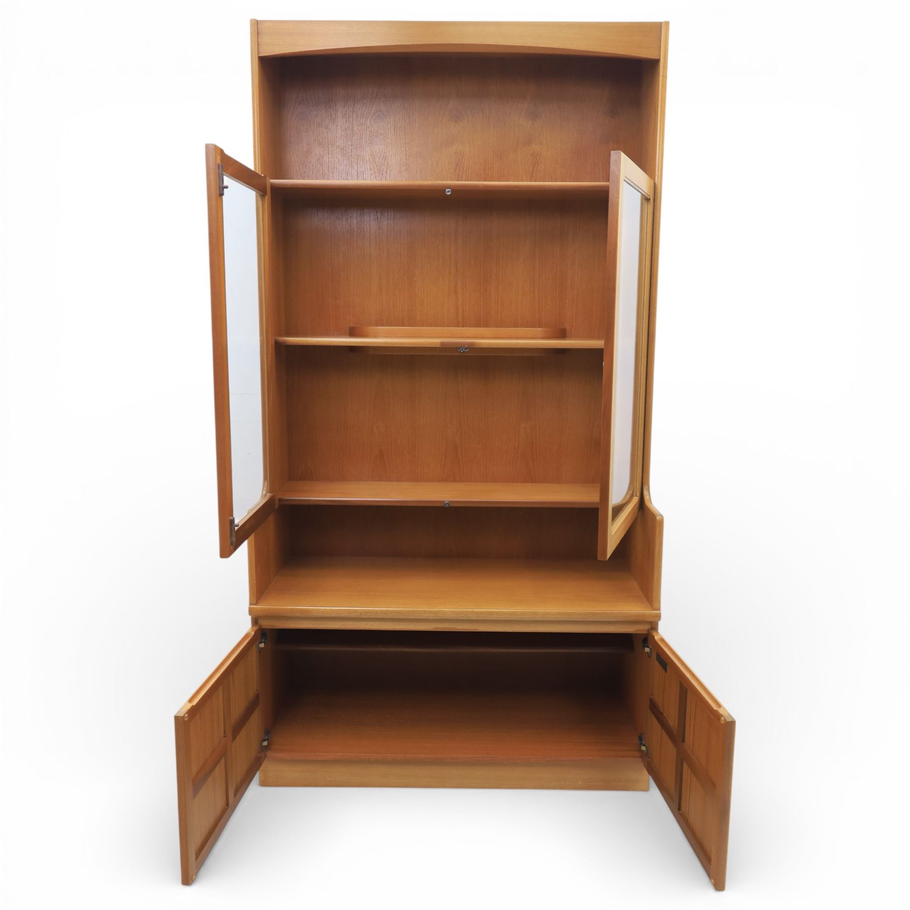 Nathan - teak wall unit, the arched open display recess above a glazed cabinet enclosed by two cupboard doors fitted with internal shelving, the lower section with a recessed serving surface over a pair of signature square panelled cupboard, raised on an integrated plinth base