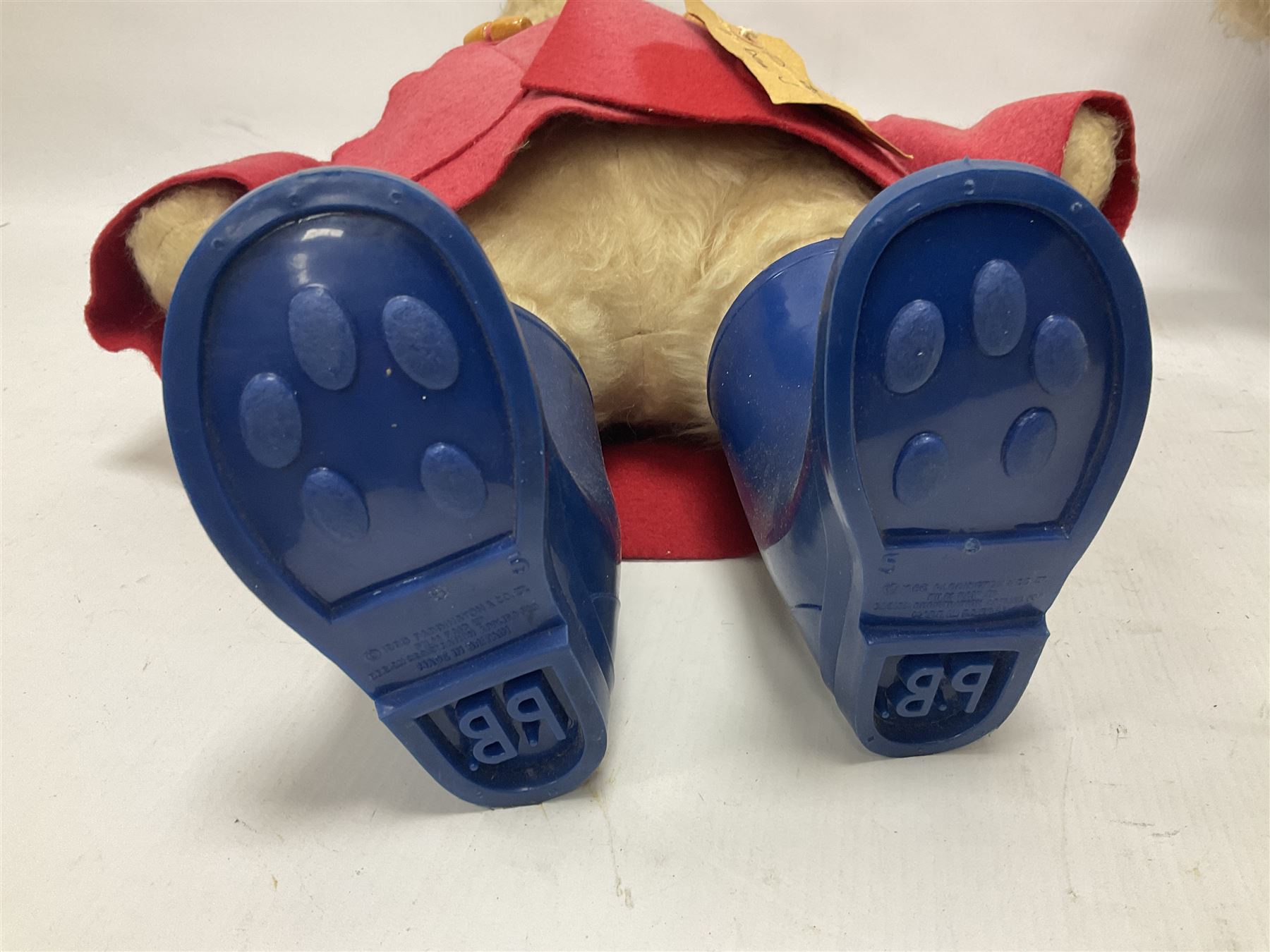 Pair of Paddington Bear teddies with amber eyes, the first example having a brown felt hat, red coat and blue PB boots with original label; the second having a grey felt hat, blue coat and blue Dunlop boots, tallest H51cm 