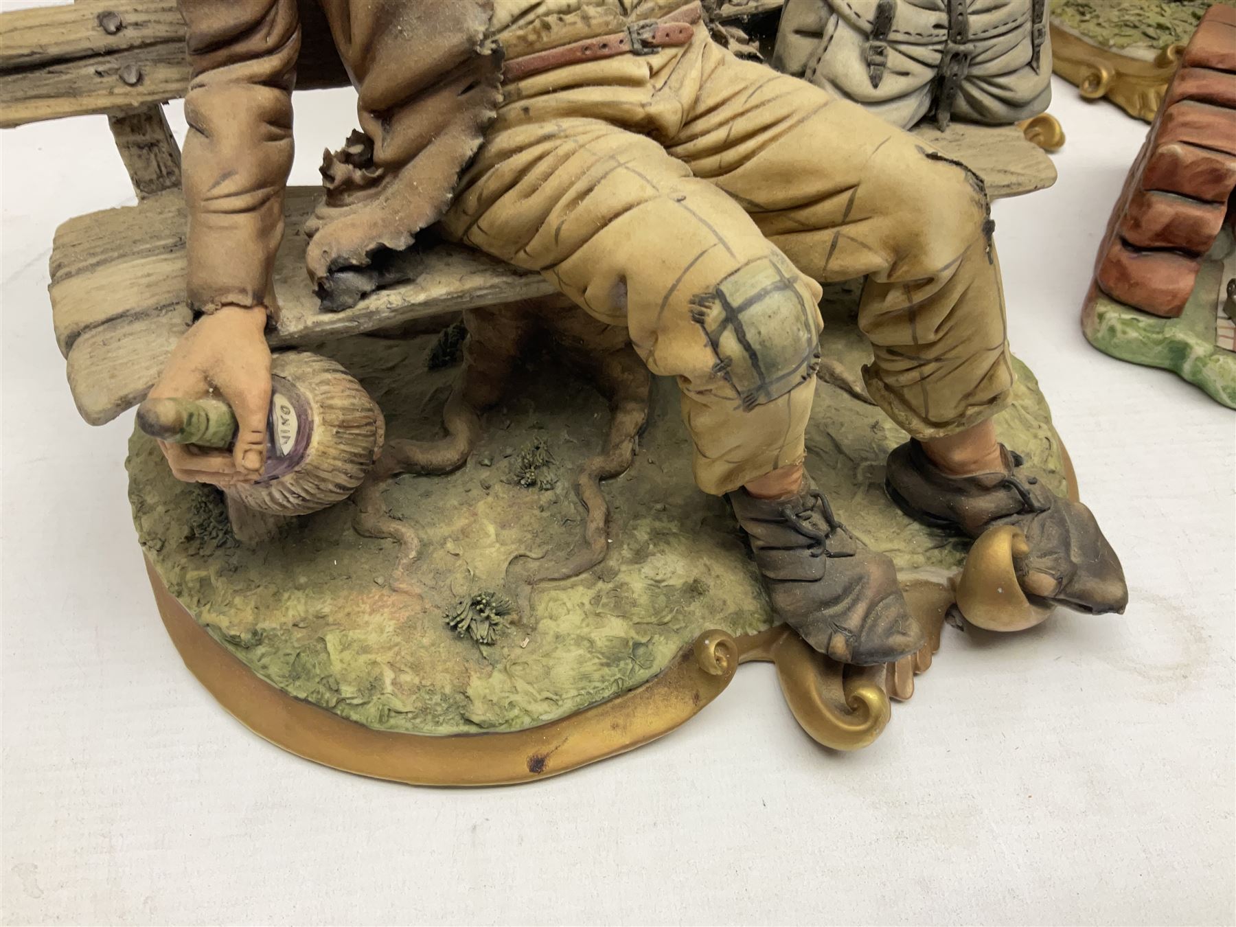 Four Capodimonte figure groups, to include tramp figures, shoemaker figure etc