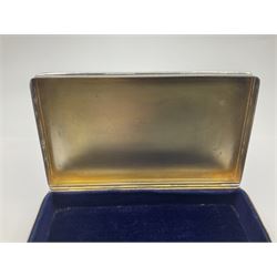 1920's silver table cigarette box, of rectangular form with engine turned decoration to the exterior, the hinged cover with central vacant rectangular panel and raised foliate rim, opening to reveal a gilt interior with later plush lining, hallmarked Charles Henry Dumenil, London 1923, H3.5cm L14.5cm D8.5cm