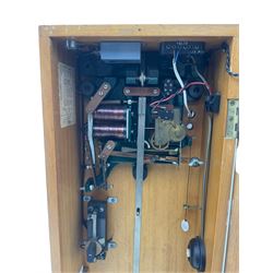 A mid-20th century Gent of Leicester(Blick Electric) Pulsynetic Master Clock in a full length glazed wooden case, with a square white dial with Arabic numerals, minute markers and baton hands, with pendulum and a record card dating from the 1970’s. 
This master clock would have been wired to send time signals to other slave dials in a large building, frequently used in hospitals, schools and factories during the 20th century
With a second electrical movement housed in a glazed square cabinet.


