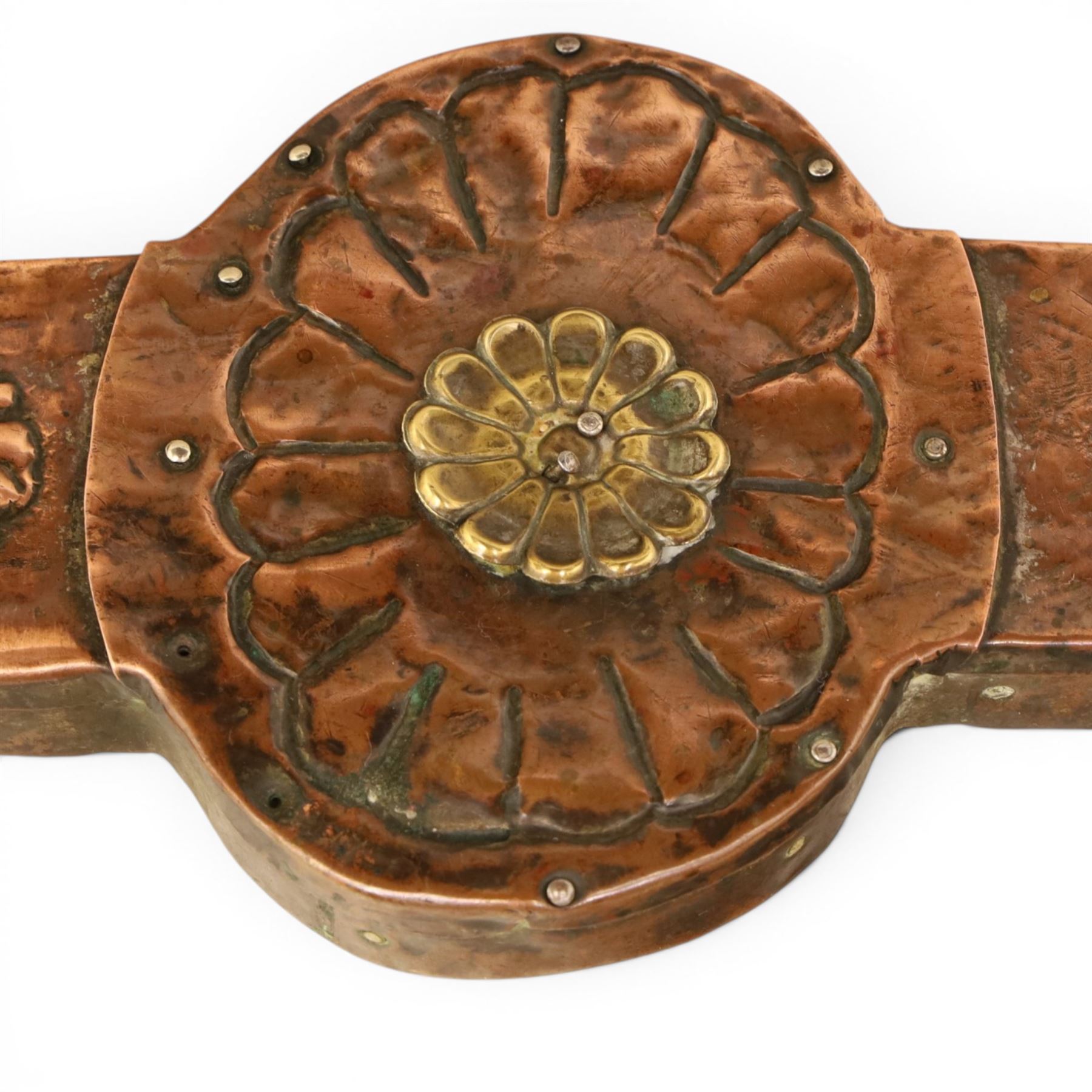 Arts and Crafts copper mounted coffee table, rectangular top with embossed foliate border and stylised corner motifs, studwork detail, on cylindrical supports united by pierced shaped stretcher with applied flowerhead bosses