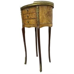 Late 20th century French design figured elm and bedside table, raised pierced gilt metal gallery over oval top, fitted with three mahogany lined drawers flanked by gilt metal mounts of female mask and foliate form, on cabriole supports