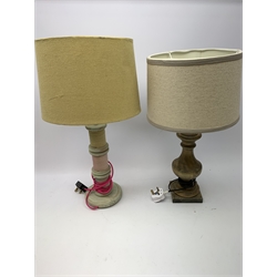 A turned wooden lamp base, with cream shade, overall H53cm, together with another wooden lamp base, the column modelled as three bobbins, with yellow shade and pink flex, overall H58cm. 