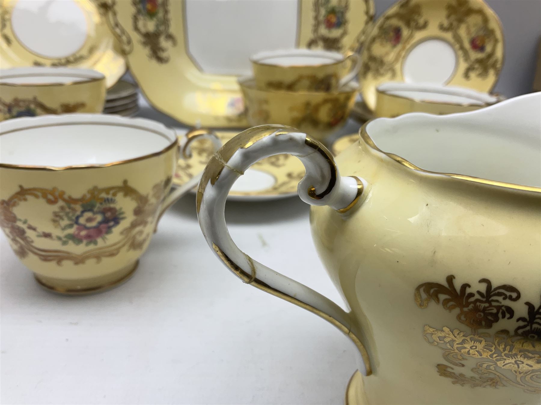 Aynsley tea service for six, decorated with floral sprays in ornate gilt detailing on cream ground, comprising six teacups and saucers, open sucrier and milk jug and cake plate, all with printed marks beneath