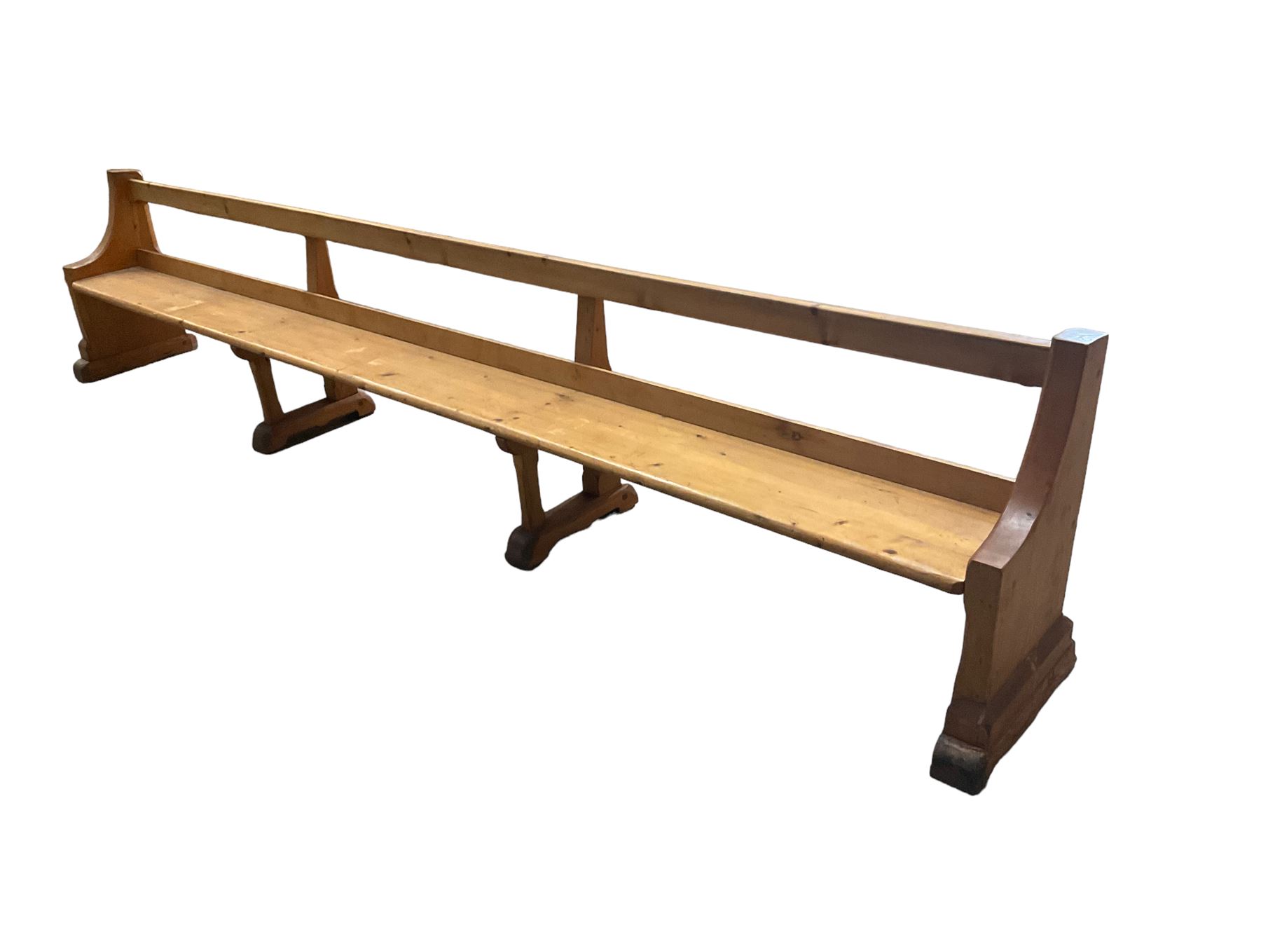 Early 20th century ecclesiastical pine bench or church pew, raised on chamfered supports with sledge feet