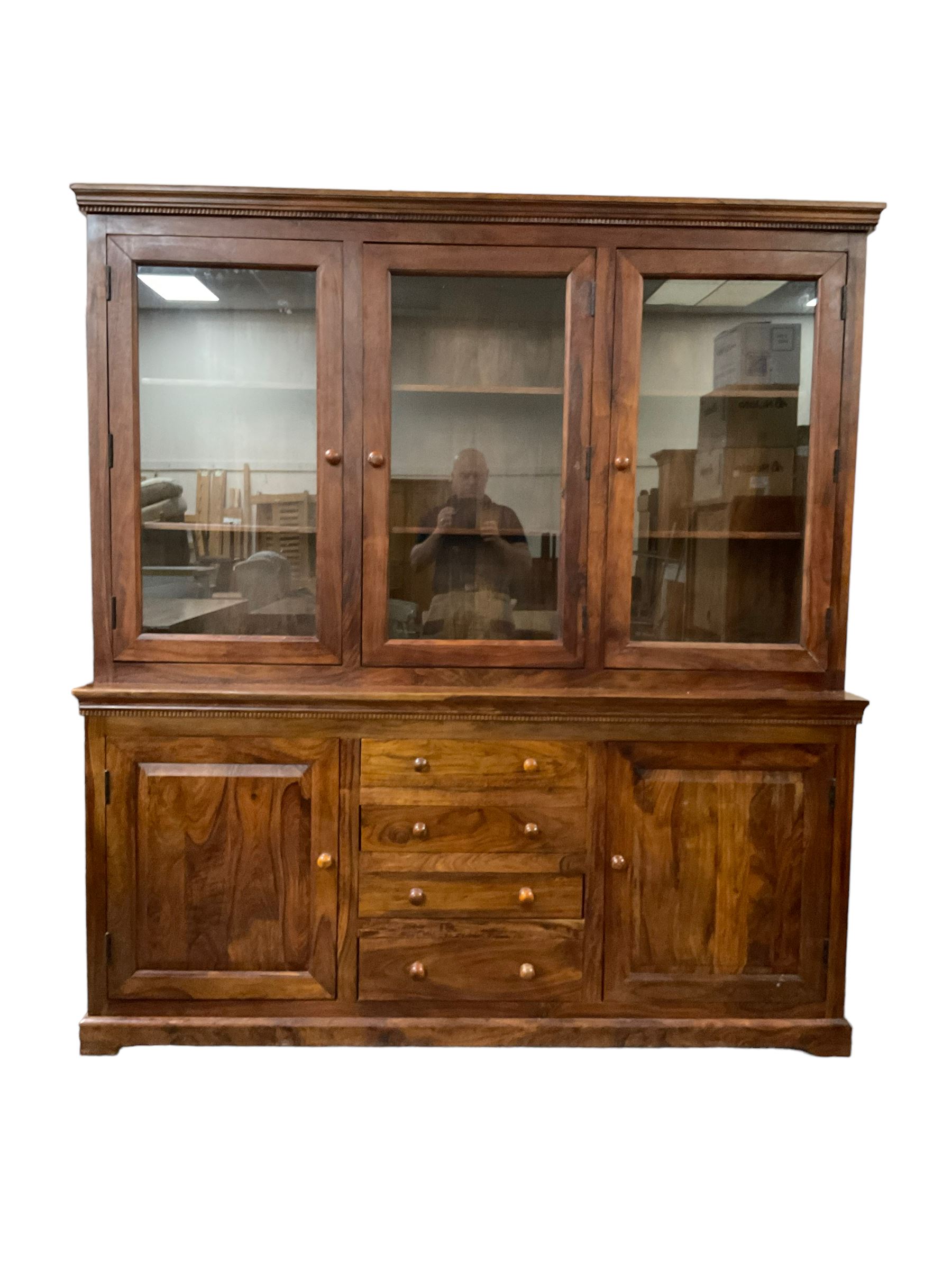 Large hardwood display wall unit, the upper section fitted with three glazed doors enclosing six shelves, the lower section fitted with four central drawers flanked by two panelled cupboards
