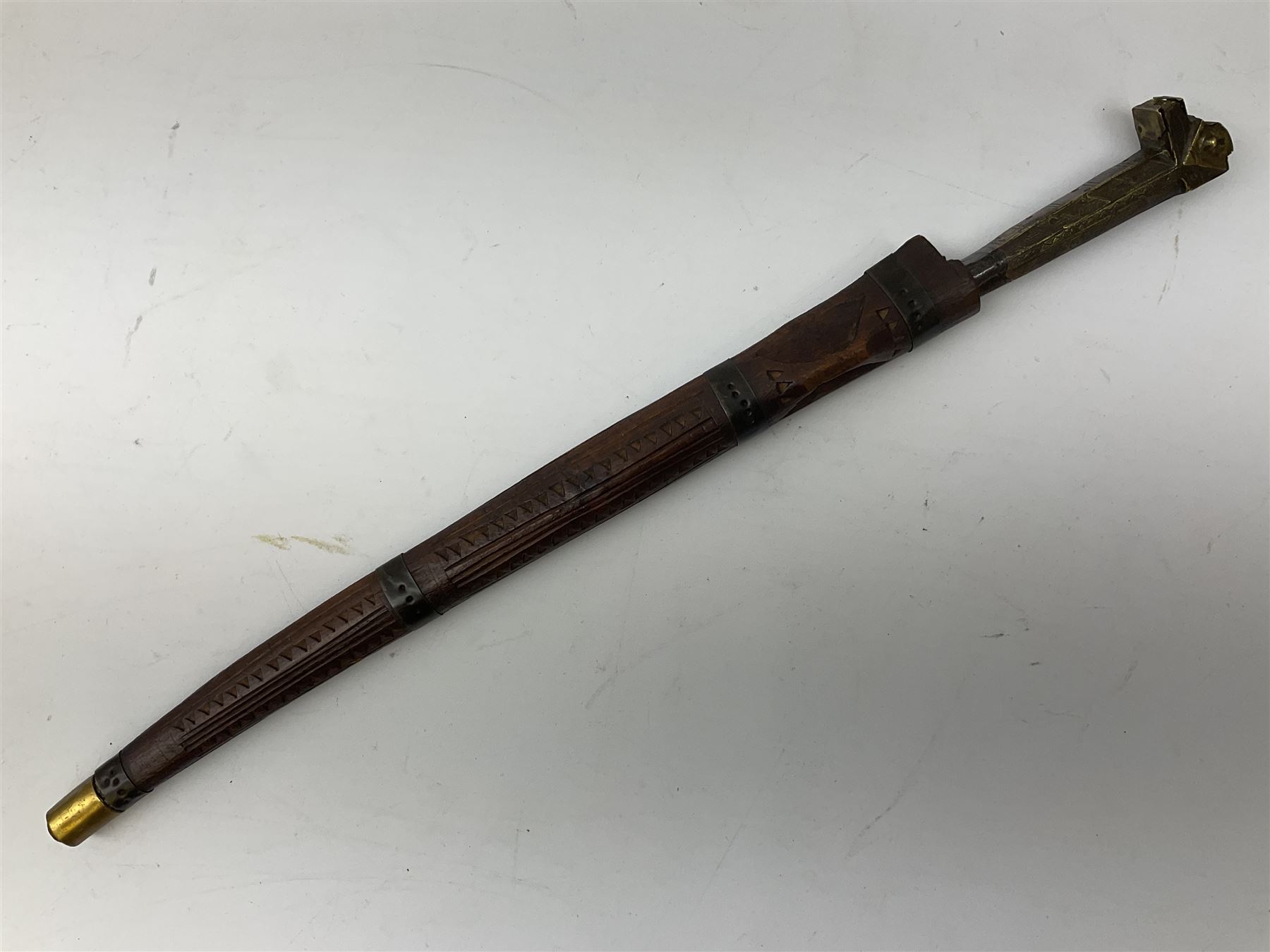 19th century Algerian Flyssa long knife, the 34cm single edged pointed decorative blade inset with yellow metal, chased brass grip with pommel as the snout of a stylised animal and carved hardwood scabbard L45cm overall