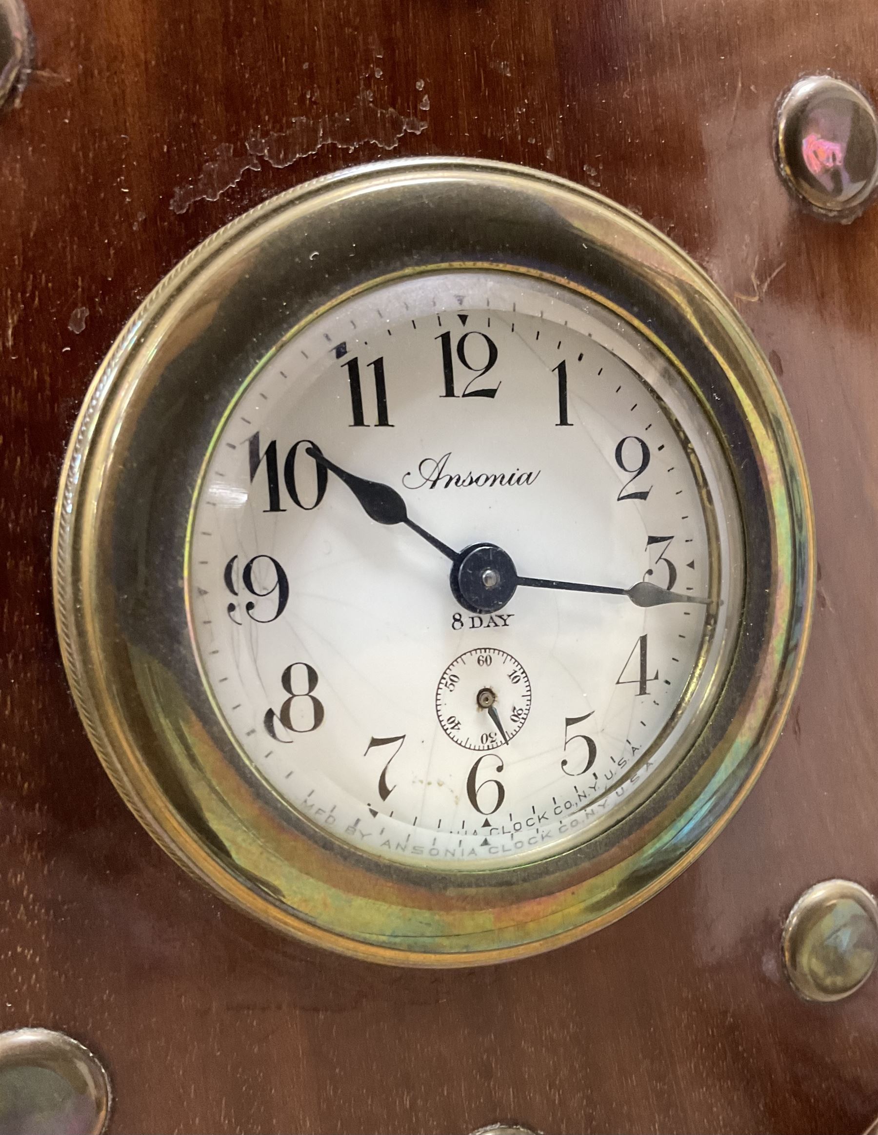 1920's-Aviation clock, mahogany case configured from part of an early 20th century aeroplane propellor, mounted on a conforming plinth with a shaped base, bolt holes filled with brass studs and fitted with an 8-day American spring driven Ansonia insertion movement with a porcelain dial, Arabic numerals, spade hands and seconds dial. Wound and set from the rear.