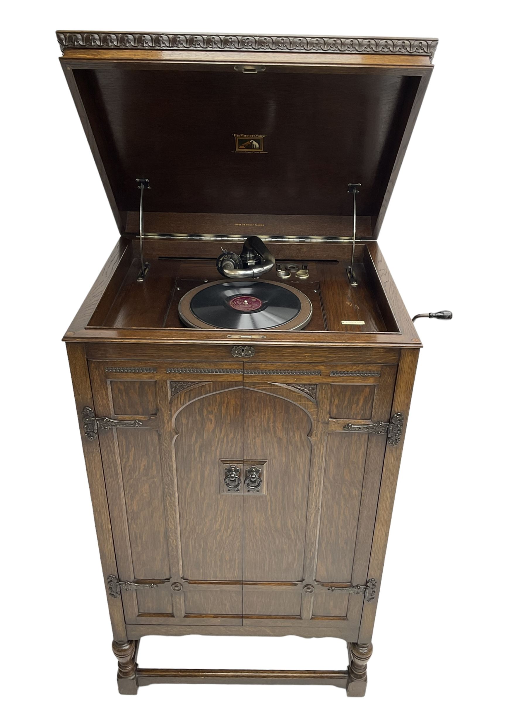 Early 20th century ‘HMV' 202 cabinet gramophone, oak cased, moulded top with foliate carved moulding hinges to reveal gramophone, two doors enclosing horn, on turned supports joined by moulded stretcher rails