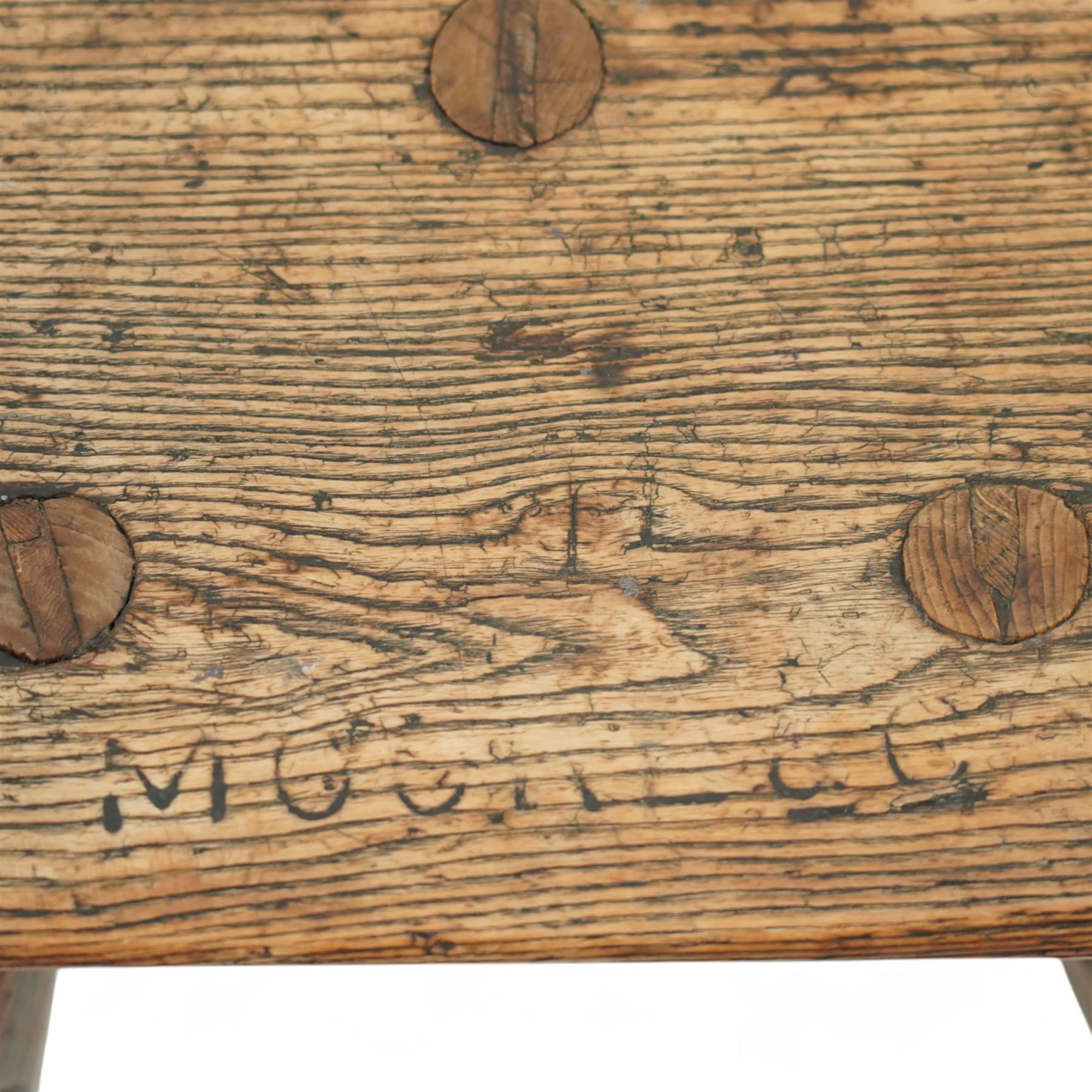 19th-century Sheffield type Cutler's stool, in elm and ash, with a solid rectangular seat, chamfered underside, on three wedge tenoned chamfered legs, the top of the seat with indistinct carved lettering