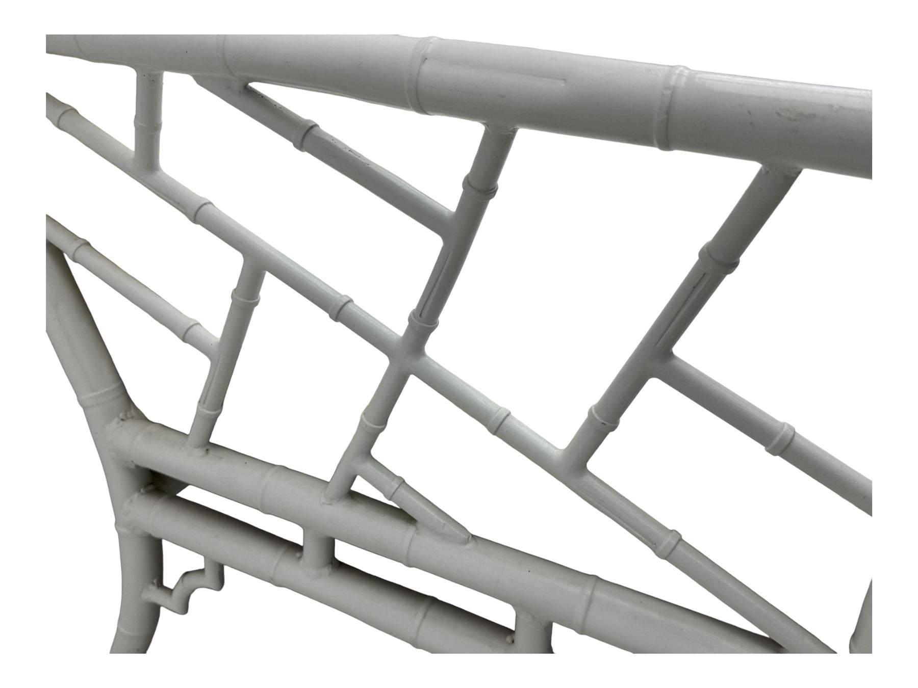 Late 20th century faux bamboo conservatory sofa, white painted frame with geometric openwork back and sides, loose cream cushions, on cylindrical supports (W134cm, D76cm, H80cm); matching armchair (W75cm, D76cm, H80cm); matching coffee table with glass insert (W46cm, D45cm, H36cm)