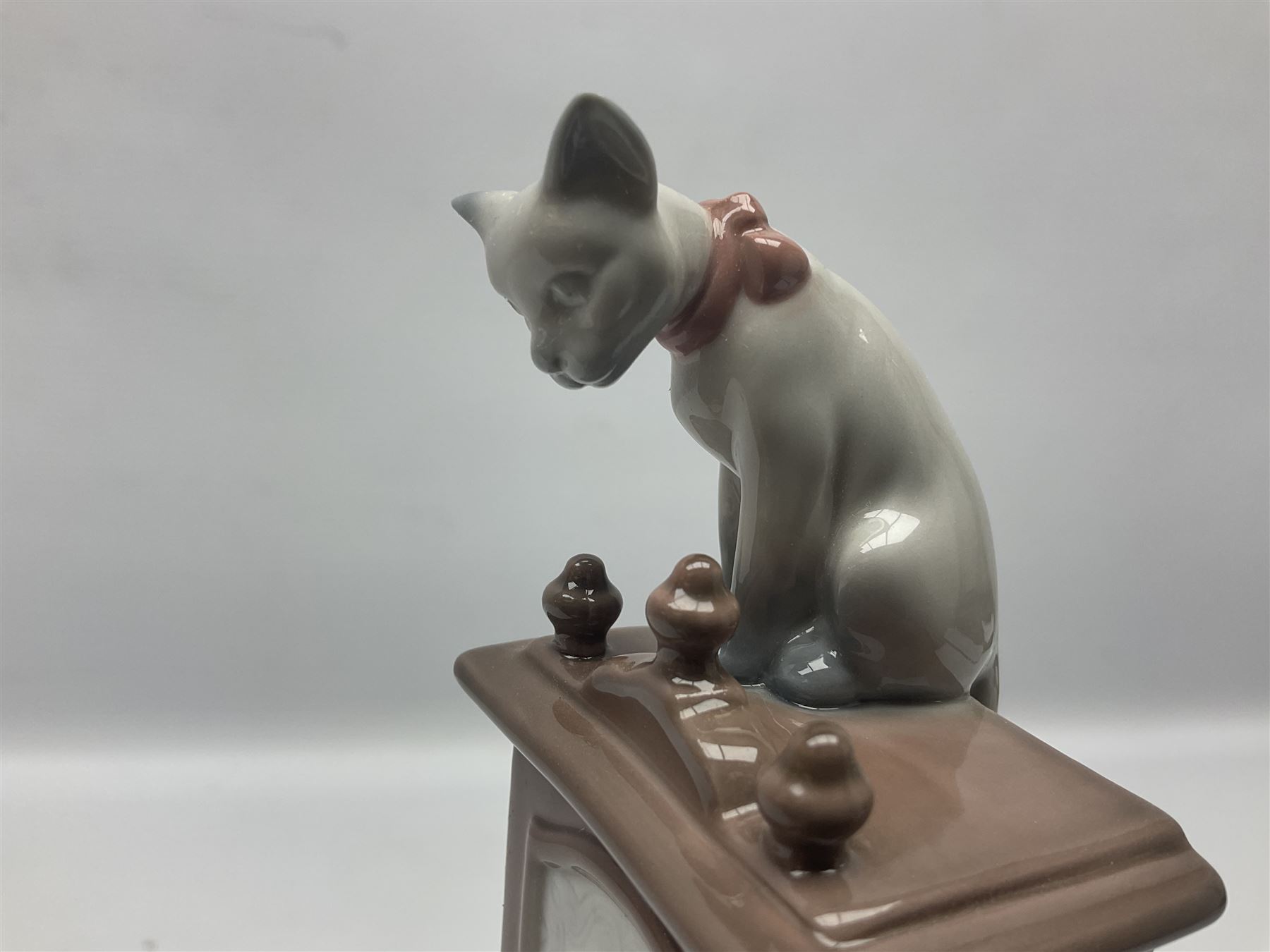 Lladro figure, Bedtime, modelled as a young girl reaching for her pet cat upon grandfather clock, sculpted by Vincente Martinez, with original box, no 5347, year issued 1986, year retired 1998, H28cm