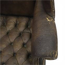 Georgian style leather wing armchair, shaped high back with outscrolled wings above padded arms and deep buttoned seat, close-nailed throughout, raised on square supports united by H-stretcher