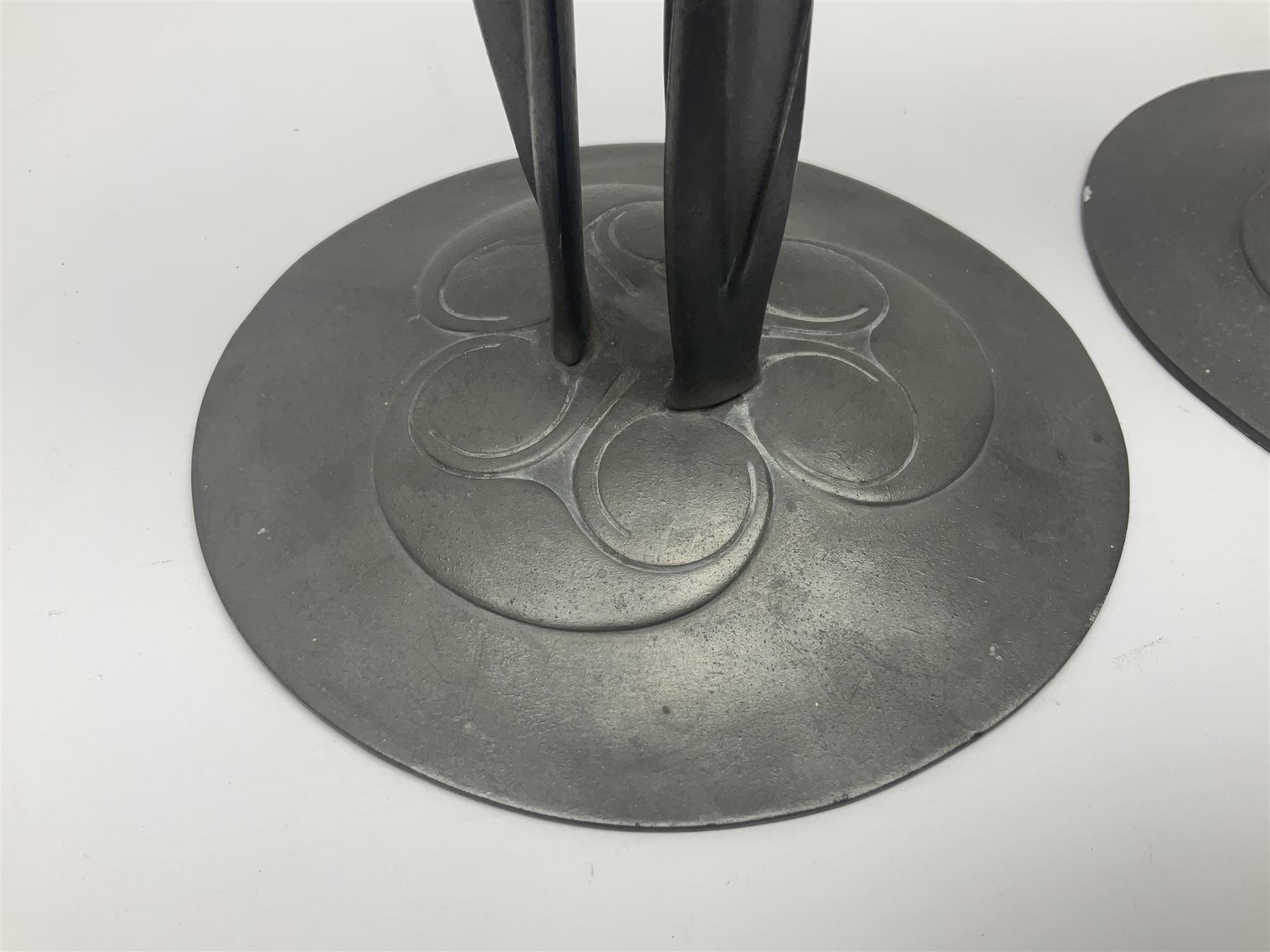 Pair of Solkets English pewter candlesticks, the bud shaped sockets raised upon three angular fin supports and a slightly domed circular base with cast stylised foliate decoration, H23cm