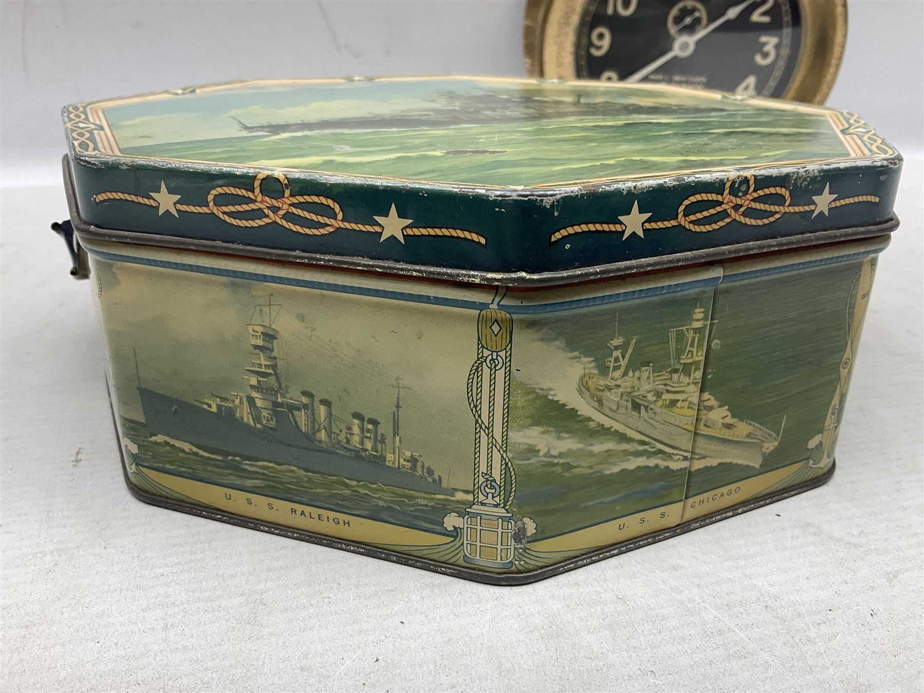WWII period US Navy Mark I deck clock, the black circular dial with Arabic numerals,  luminous dot markers and subsidiary seconds dial marked 'Mark I Deck Clock U.S. Navy 15211 1941', in bronze bulk head case D20cm; and a Loose-Wiles Biscuit Company octagonal tin decorated with nine different US Warships (2)