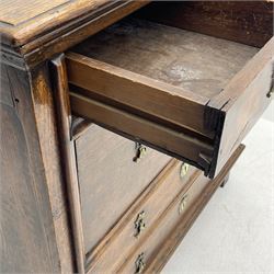 18th century oak chest, moulded rectangular top over two short and three long drawers, panelled sides, the drawer fronts fitted with ornate cast metal escutcheons and drop handles, lower applied mould, on stile supports 