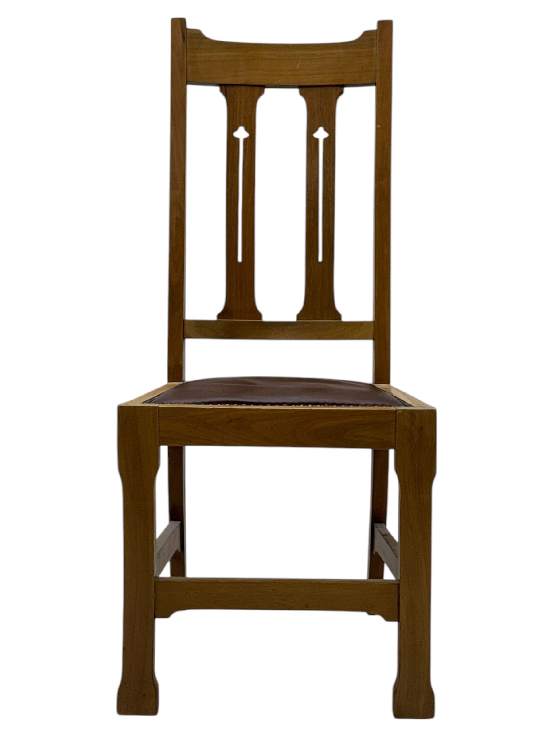 Contemporary light oak round extending dining table with four chairs, table has fold out leaf attached underneath on four out-swept legs, Oak chairs with straight top rail over twin slat back with pierced motifs, brown leather seat with brass studs, square legs joined by plain stretcher 