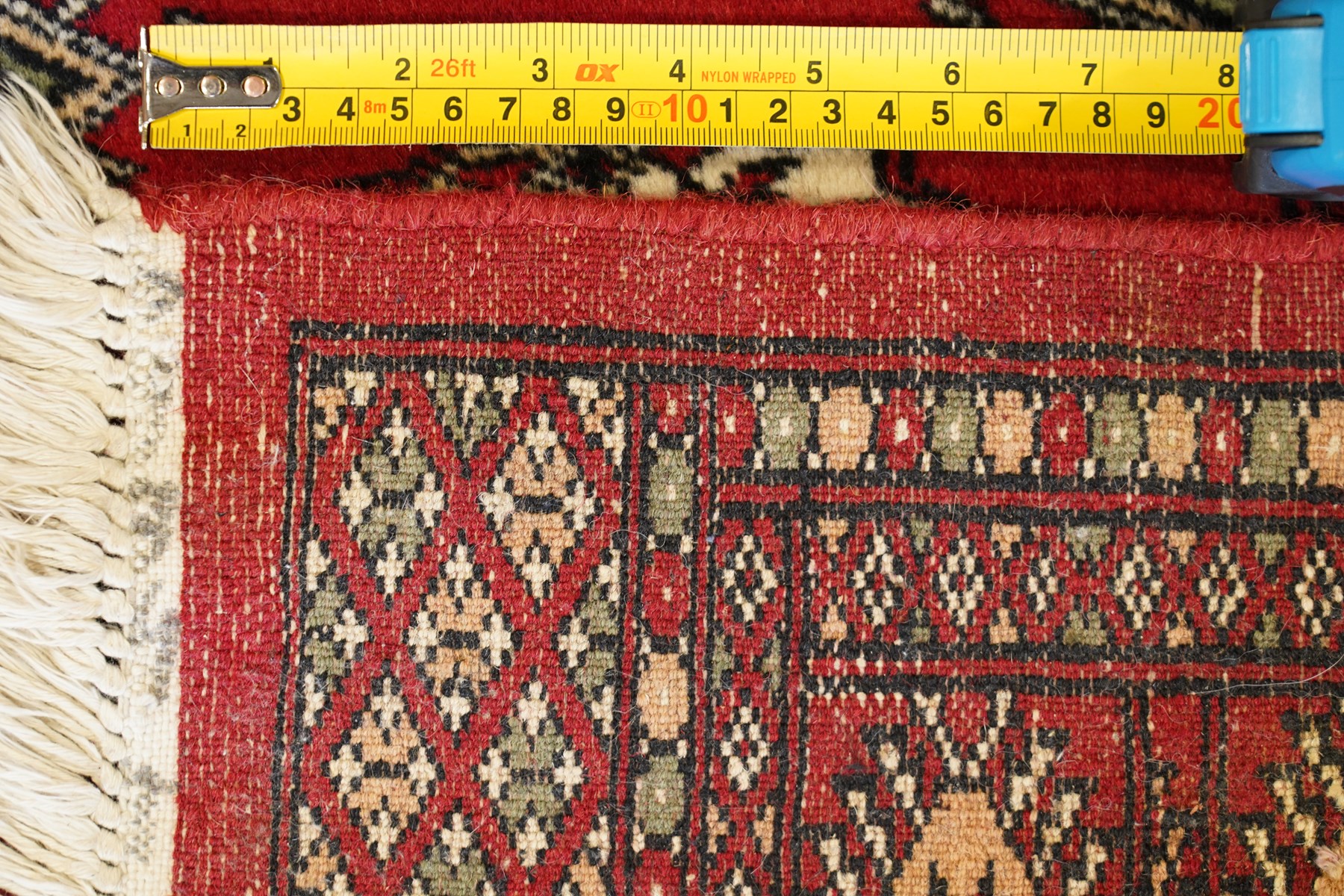 Two Afghan Bokhara crimson ground rugs, the fields decorated with repeating Gul motifs with geometric guard bands (126x190 & 157x250)
