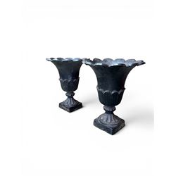 Pair of Victorian large scale cast iron garden urns, flared petal shaped rim with tapering waist, gadrooned base on square plinth, finished in black paint