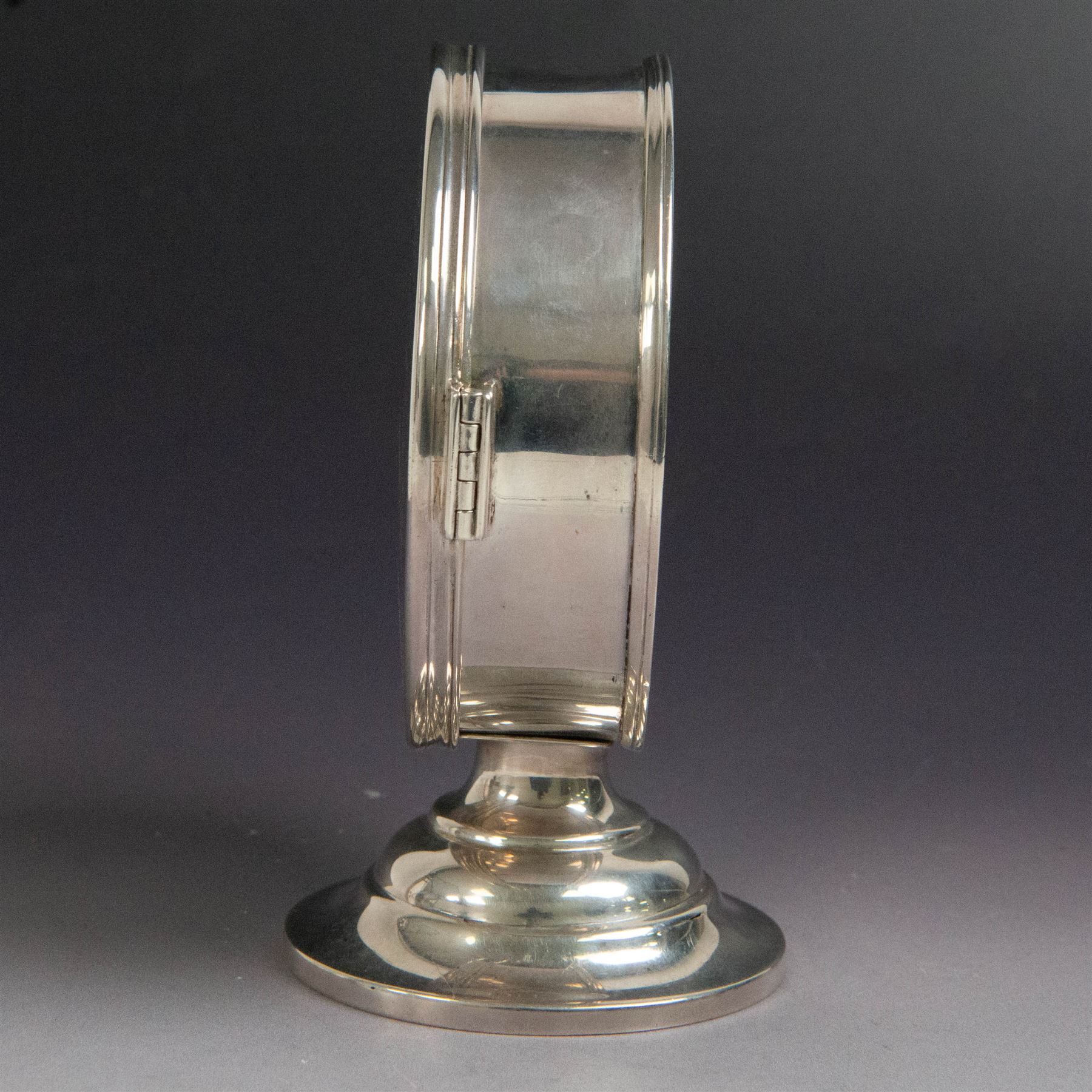 Late Victorian silver lunette, of plain circular form with hinged cover opening to reveal gilt interior, upon a circular domed foot, hallmarked Lambert & Co, London 1897, H13cm