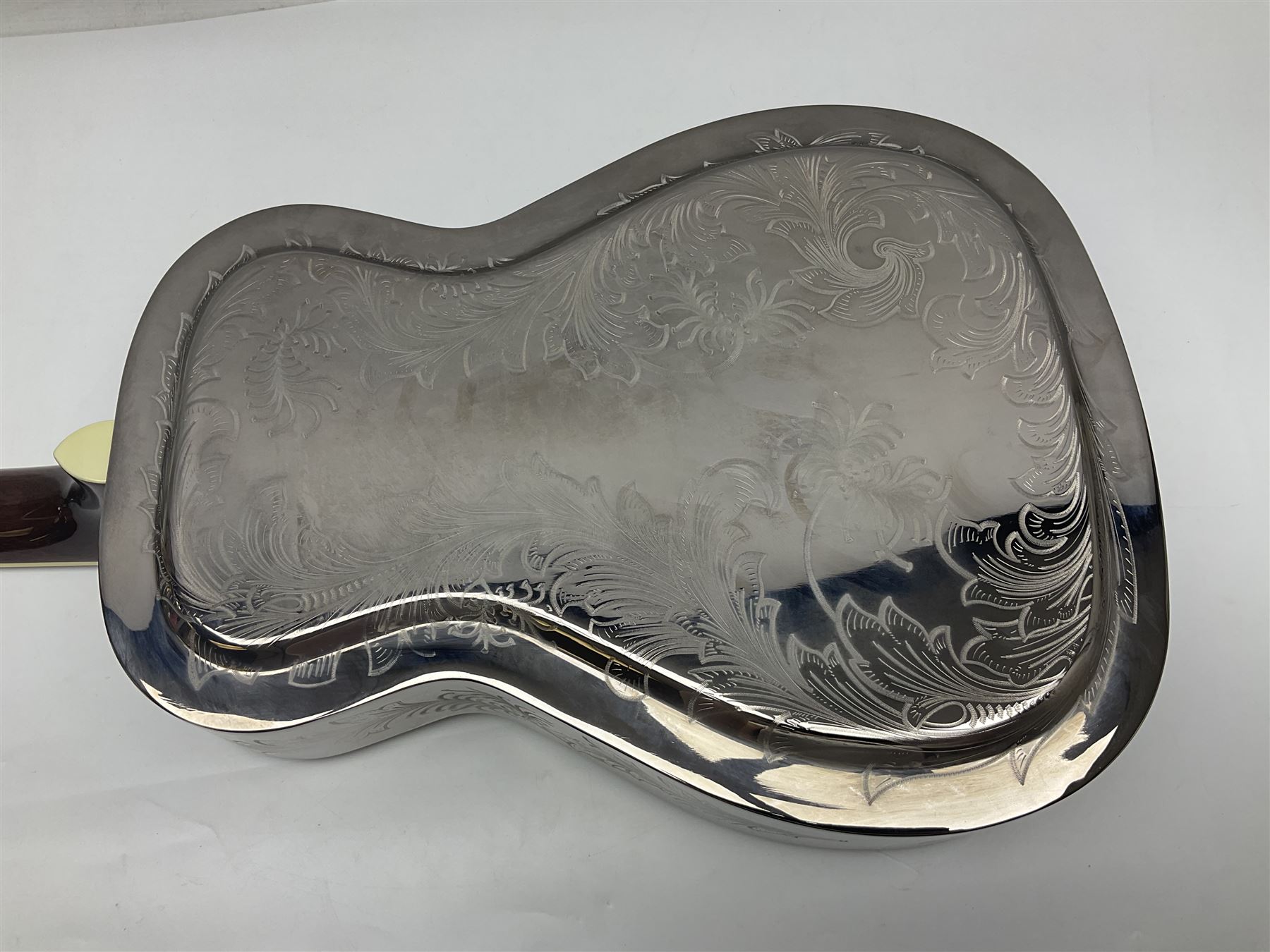 Ozark metal cased resonator guitar with all over chased foliate decoration to the polished finish and mother-of-pearl inlay to the fretboard L100cm; in Stagg hard carrying case