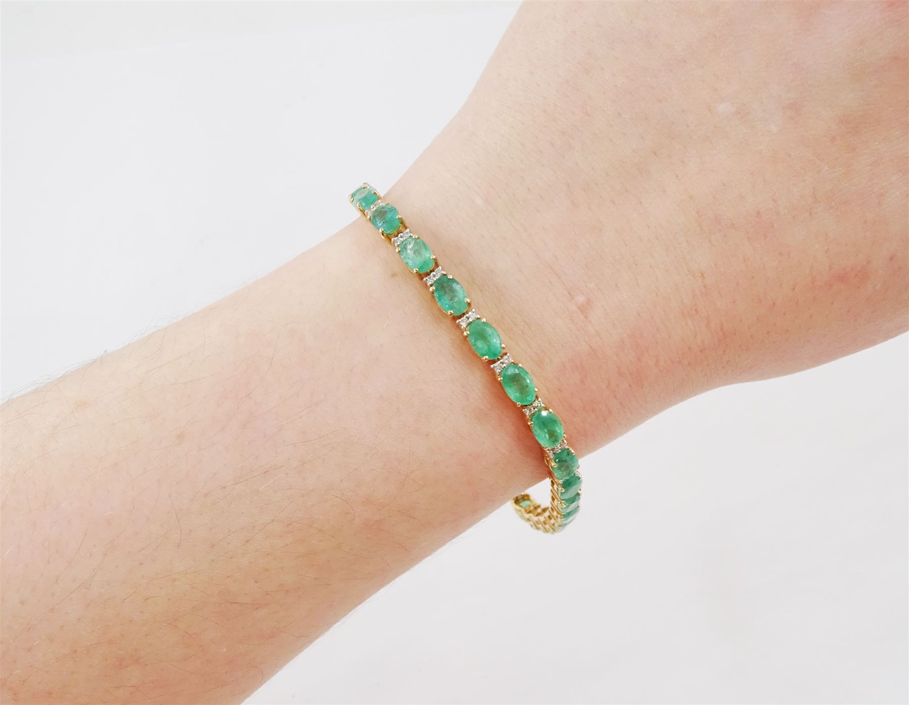 18ct gold emerald and diamond bracelet, twenty-seven oval cut emeralds, each spaced by two round brilliant cut diamonds, stamped 18K, total emerald weight approx 12.35 carat, total diamond weight approx 0.50 carat